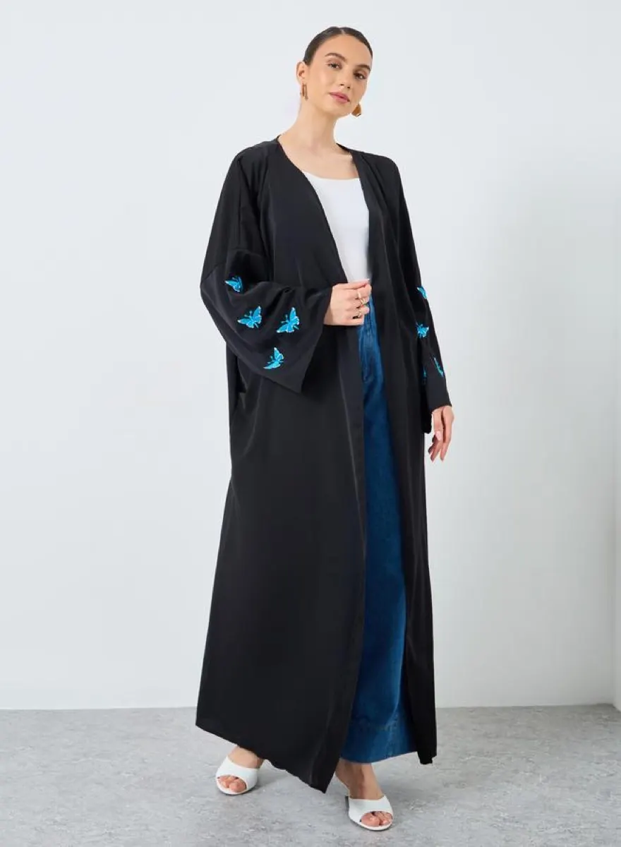 Model wearing a black butterfly sleeve abaya